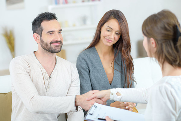 73398183 – man shaking hands with lady holding clipboard